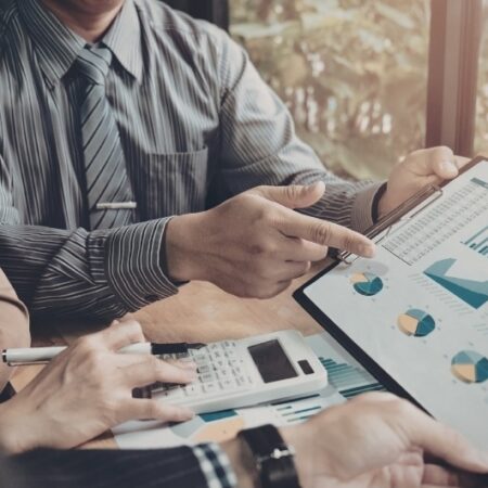 Financial advisors reviewing annuity performance data on a tablet, highlighting the importance of the annual annuity review for maximizing returns.